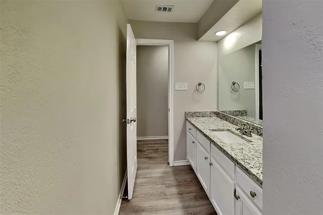 a bathroom with a granite countertop sink and a mirror