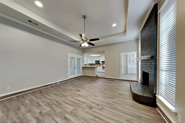 a view of an empty room with a window and fireplace