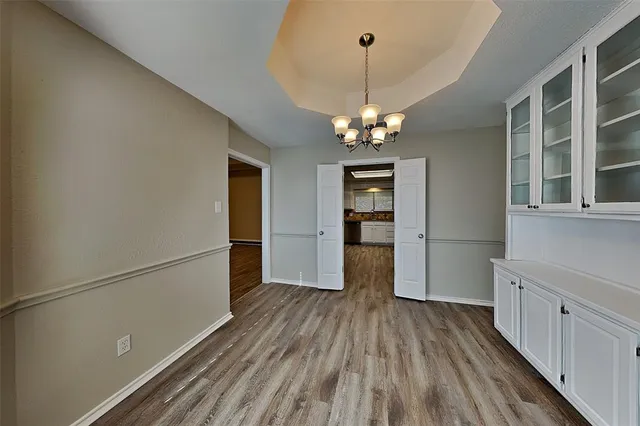 a view of a kitchen with a white cabinet and wooden floor