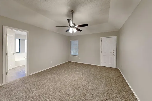 an empty room with fan and windows