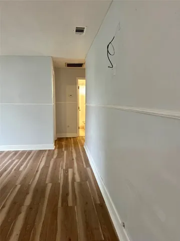 a view of a room with wooden floor and white walls