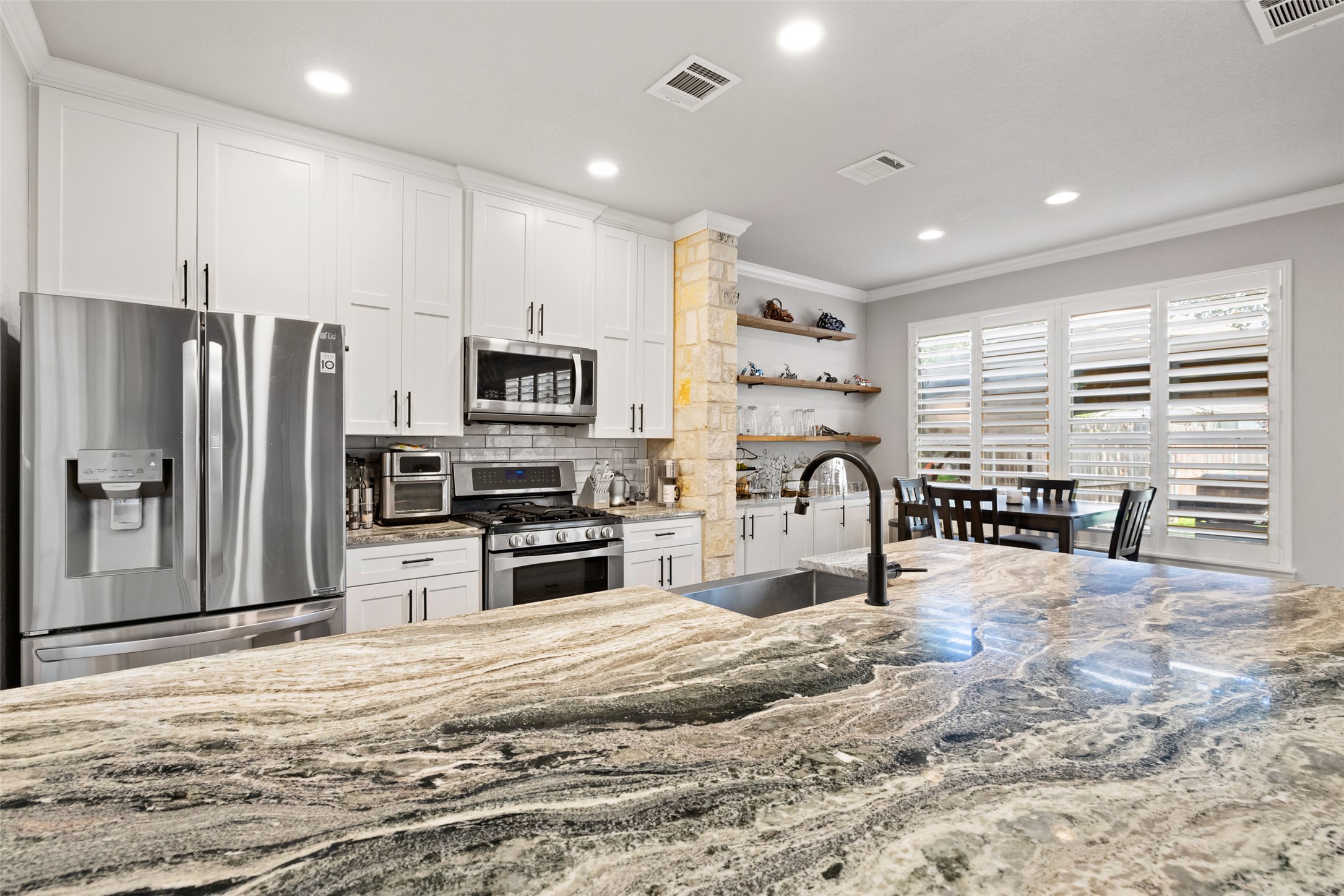 134 Prairie Springs Cove Georgetown, TX 78626 - Photo 11 of 34 a kitchen with granite countertop a refrigerator and a stove top oven