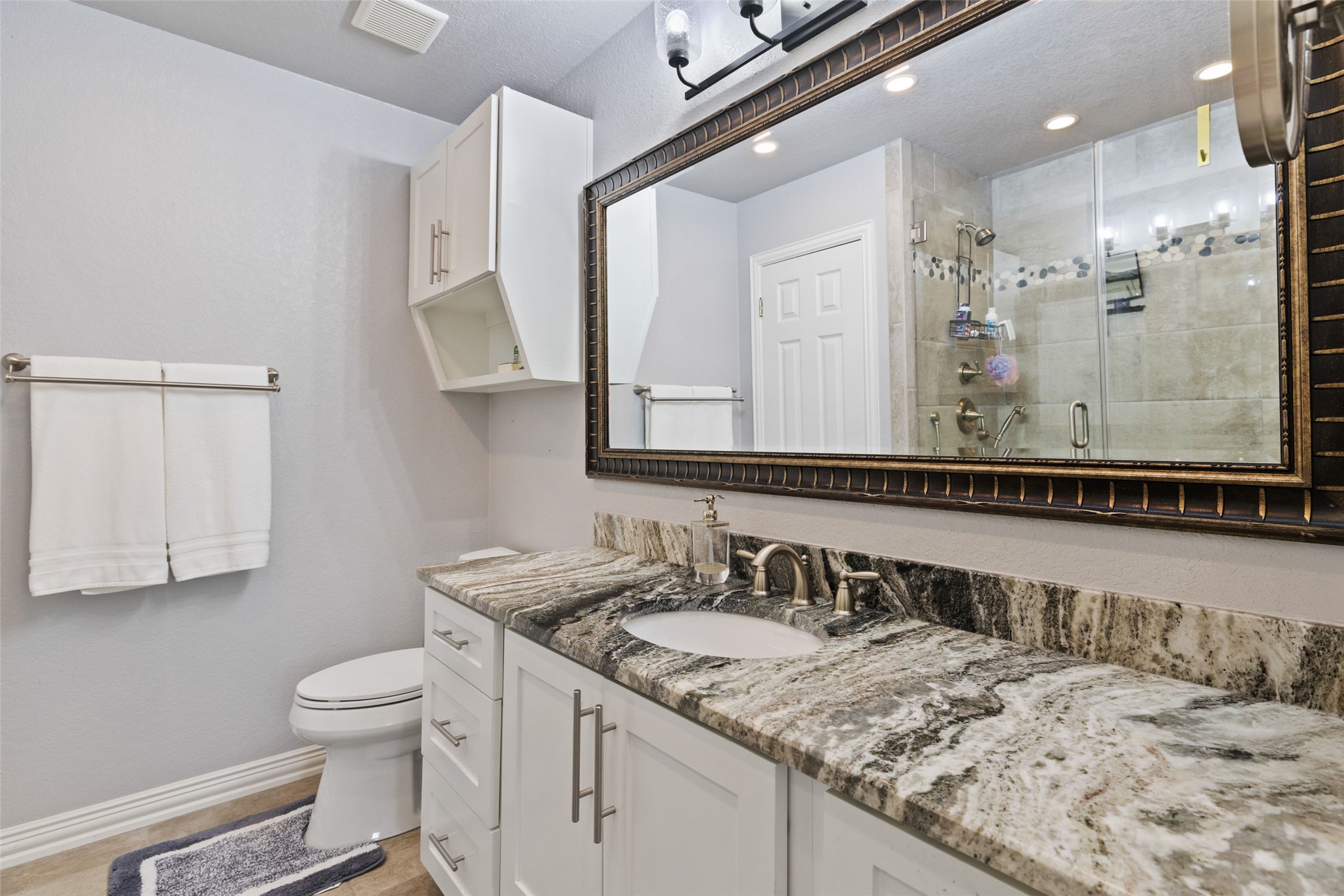 134 Prairie Springs Cove Georgetown, TX 78626 - Photo 20 of 34 a bathroom with a granite countertop sink a toilet and a mirror