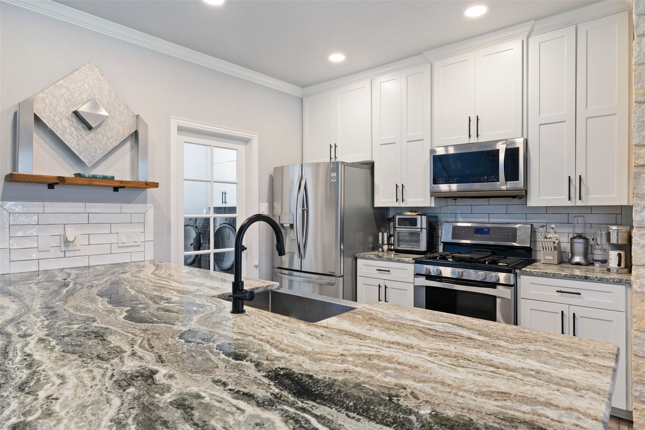 134 Prairie Springs Cove Georgetown, TX 78626 - Photo 10 of 34 a kitchen with stainless steel appliances granite countertop a stove a sink and a microwave