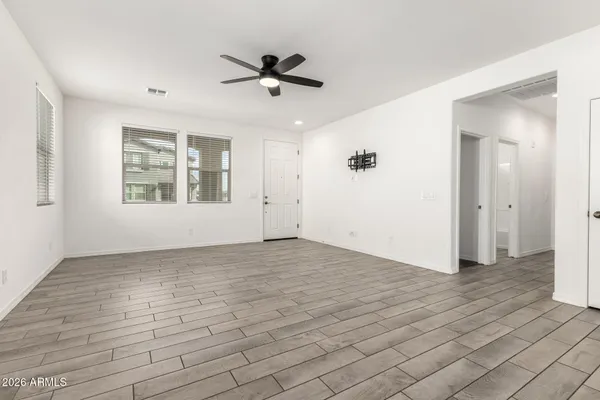 a view of a big room with wooden floor and windows