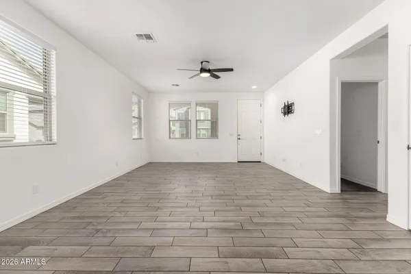 a view of an empty room and kitchen view