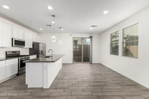 a kitchen with stainless steel appliances granite countertop a refrigerator and a stove top oven