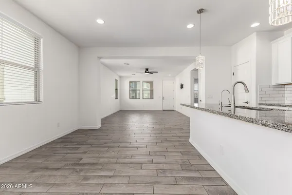 a kitchen with stainless steel appliances granite countertop a refrigerator sink and white cabinets