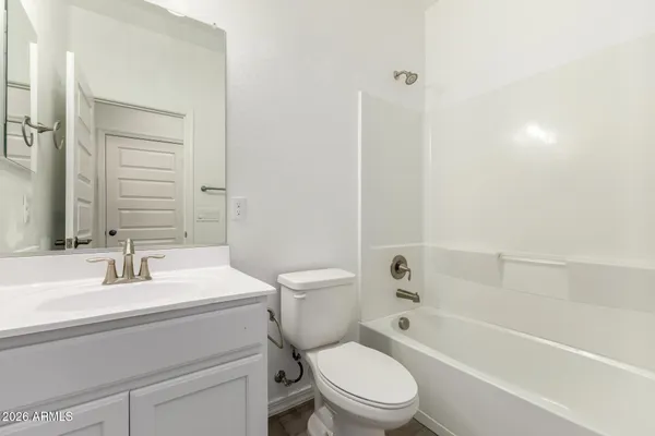 an empty room with windows and ceiling fan