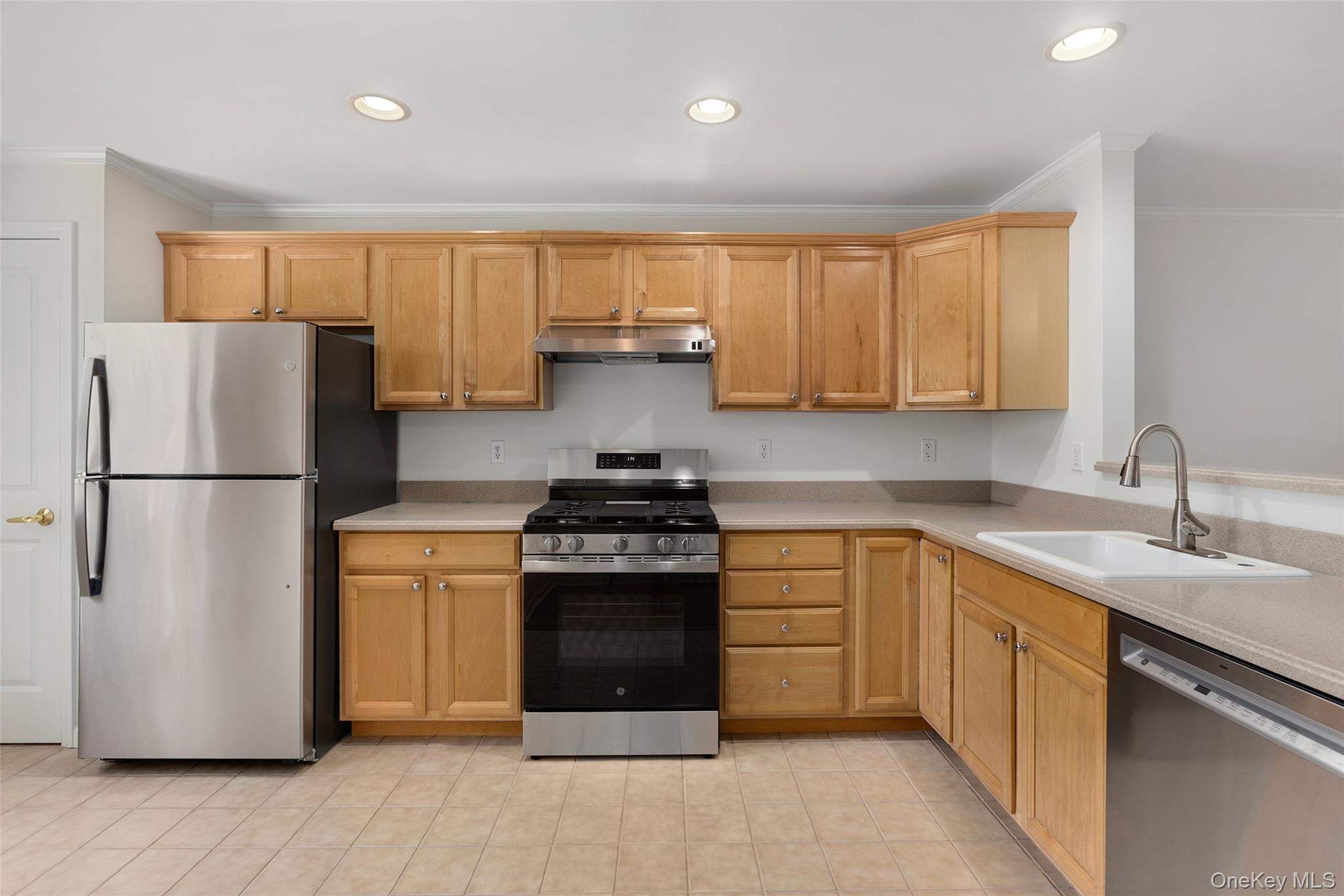 223 Viewpoint Terrace Peekskill, NY 10566 - Photo 7 of 30 Kitchen with stainless steel appliances, ornamental molding, under cabinet range hood, recessed lighting, and light tile patterned floors