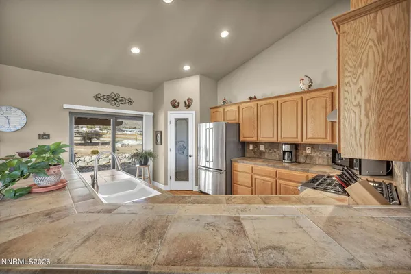 a large kitchen with a lot of counter space and wooden floor
