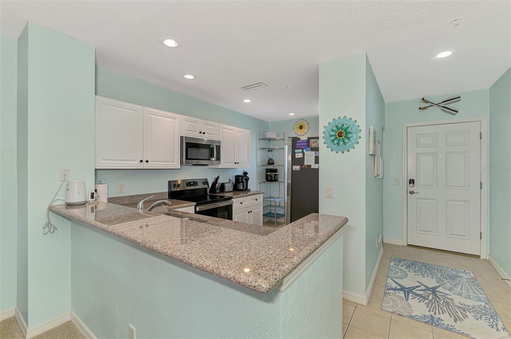 8409 Placida Road, Unit 206 Placida, FL 33946 - Photo 19 of 67 a kitchen with granite countertop a sink stainless steel appliances and white cabinets