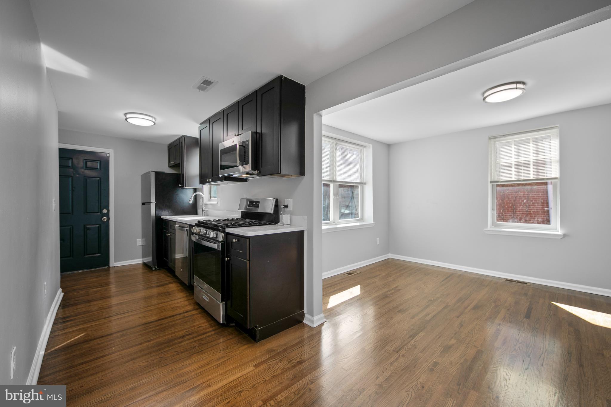 1226 America Road Camden, NJ 08104 - Photo 11 of 30 a kitchen with stainless steel appliances granite countertop a refrigerator stove top oven and cabinets with wooden floor