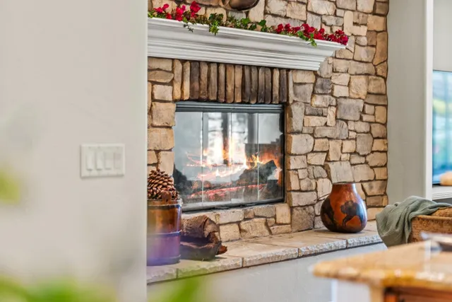 a living room with furniture a fireplace and a floor to ceiling window
