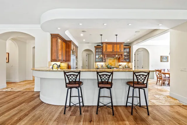 a kitchen with stainless steel appliances granite countertop a stove a sink and a wooden floors