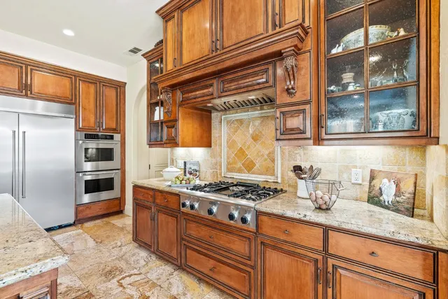 a kitchen with stainless steel appliances granite countertop a refrigerator and a stove