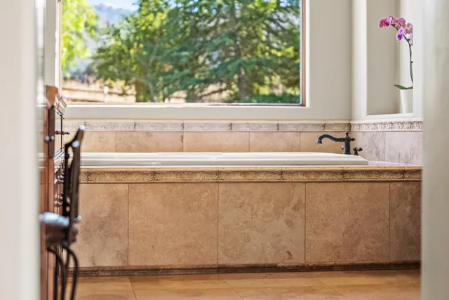 a spacious bedroom with a bed and a lamp