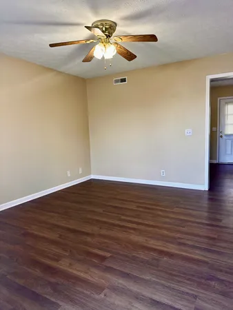 a view of room with wooden floor and ceiling fan