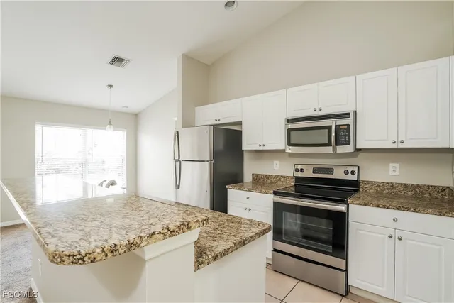 a kitchen with kitchen island granite countertop a stove sink and microwave