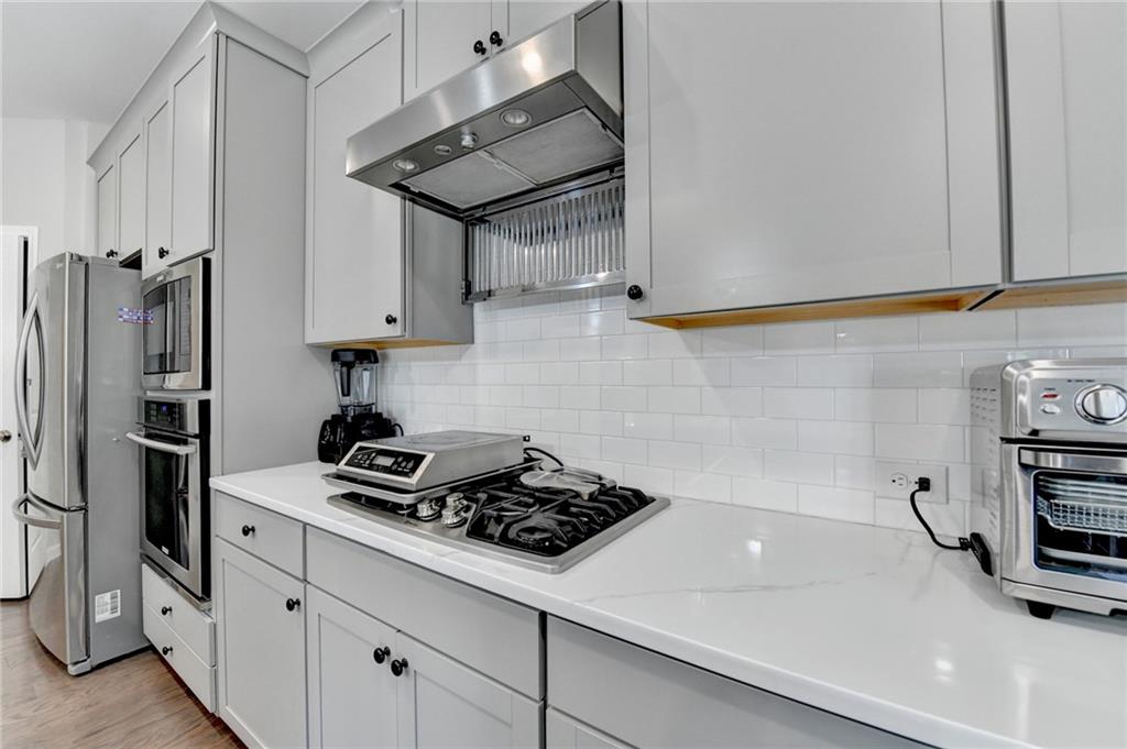 955 Laura Jean Court Buford, GA 30518 - Photo 25 of 68 a kitchen with stainless steel appliances a sink a stove and a refrigerator