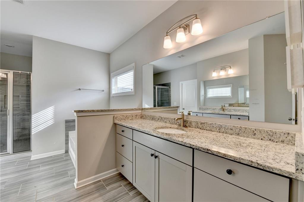 955 Laura Jean Court Buford, GA 30518 - Photo 41 of 68 a bathroom with a granite countertop sink and a mirror