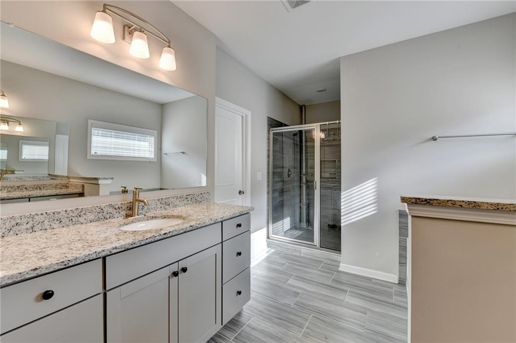 955 Laura Jean Court Buford, GA 30518 - Photo 42 of 68 a bathroom with a granite countertop sink and a mirror