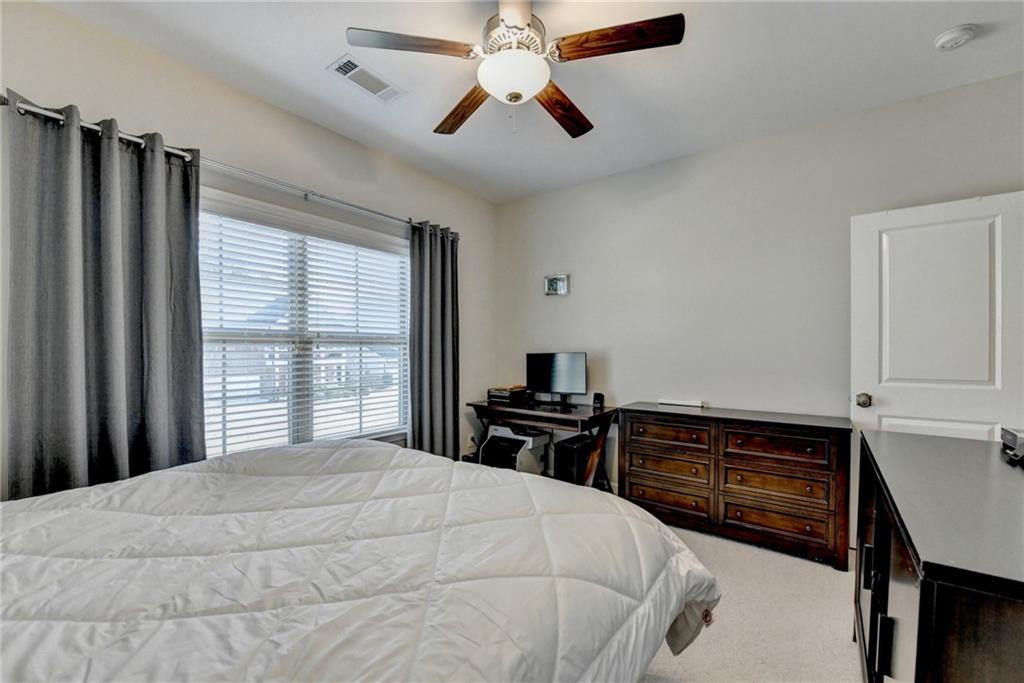 955 Laura Jean Court Buford, GA 30518 - Photo 53 of 68 a bedroom with a bed and a chandelier