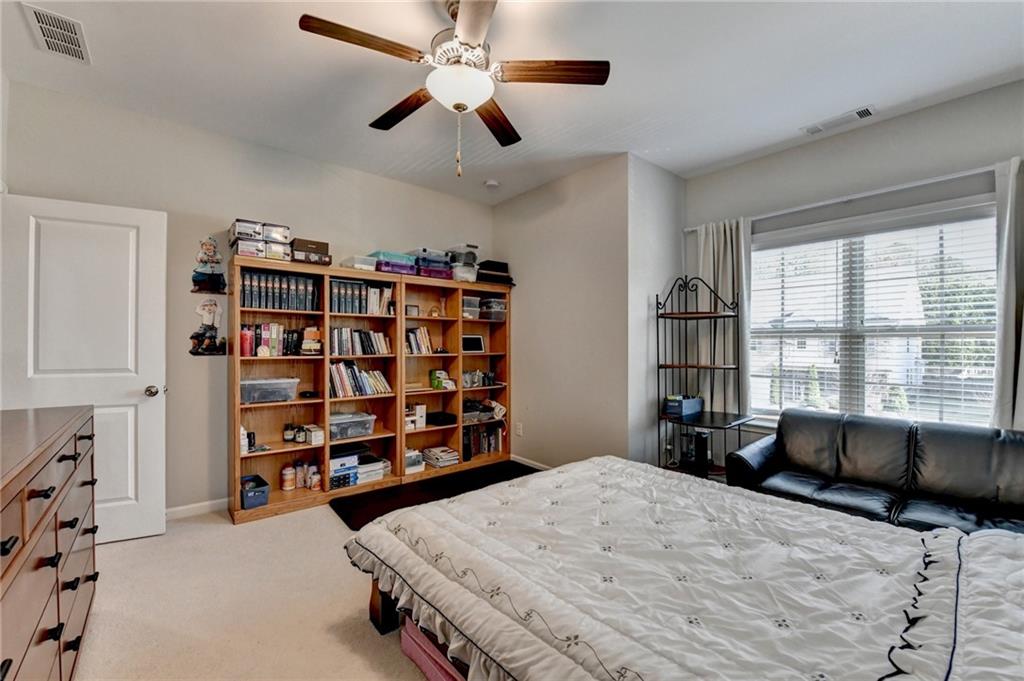 955 Laura Jean Court Buford, GA 30518 - Photo 58 of 68 a bedroom with a bed a large window and book shelf