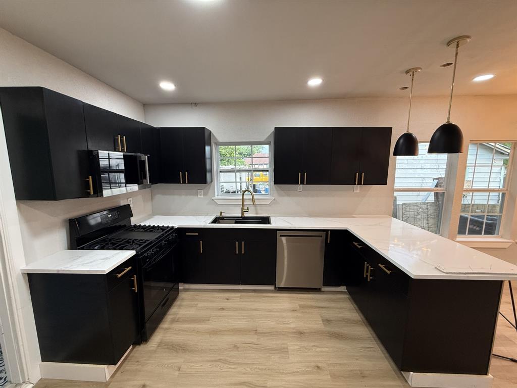 758 Bethpage Avenue Dallas, TX 75217 - Photo 2 of 20 a large kitchen with stainless steel appliances a stove a sink dishwasher a refrigerator and a microwave oven with wooden floor