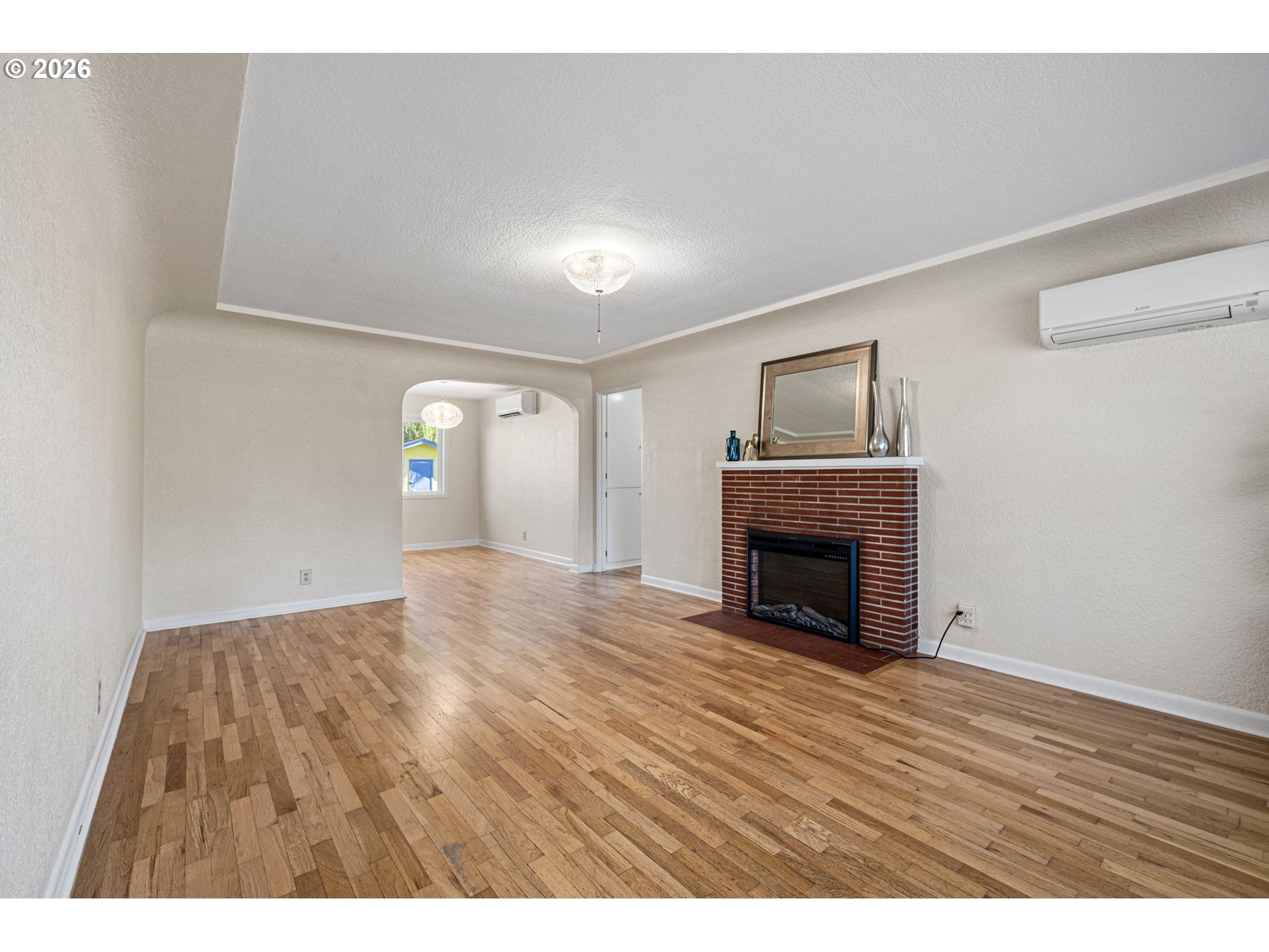 1255 Taylor Street Eugene, OR 97402 - Photo 4 of 48 a view of an empty room with wooden floor fireplace and a window