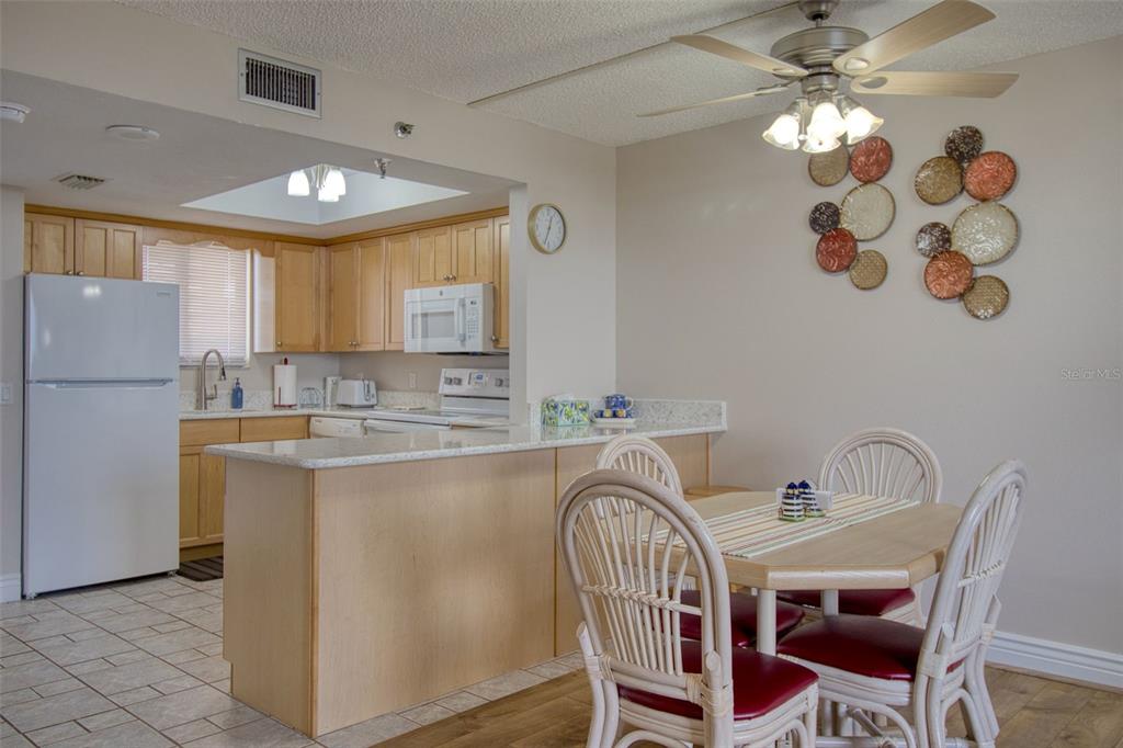 5915 Sea Ranch Drive, Unit 704 Hudson, FL 34667 - Photo 24 of 62 a kitchen with a dining table chairs sink and cabinets