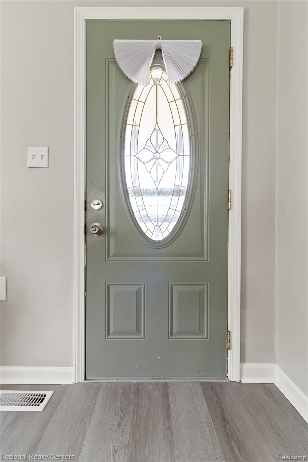 26862 Yale Street Inkster, MI 48141 - Photo 7 of 34 Sage-colored entry door with an oval stained-glass insert, complemented by light gray wall paint and white trim