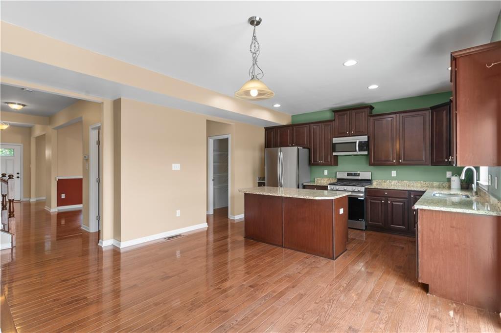 215 Long Ridge Drive Coraopolis, PA 15108 - Photo 14 of 50 a kitchen with stainless steel appliances granite countertop a refrigerator a sink dishwasher a oven and a dining table with wooden floor