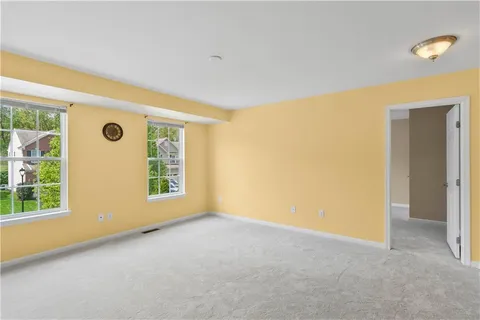 a view of an empty room with a chandelier fan