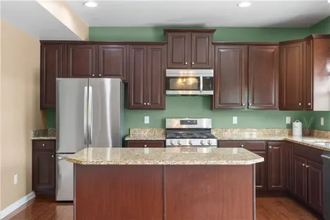 a kitchen with stainless steel appliances granite countertop a sink and a stove