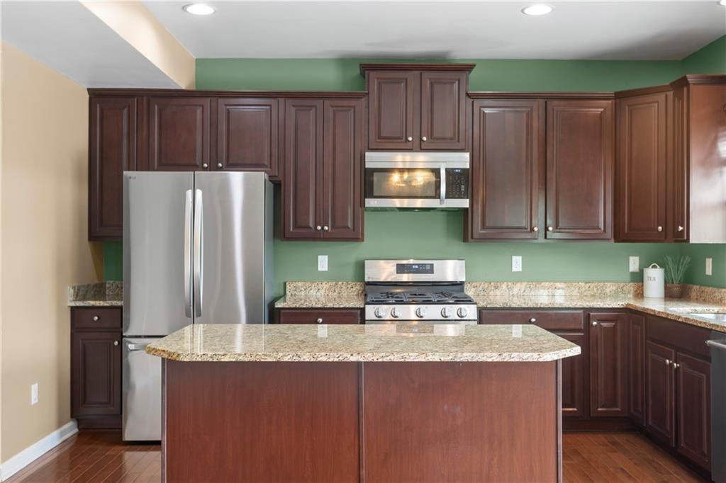 215 Long Ridge Drive Coraopolis, PA 15108 - Photo 7 of 50 a kitchen with granite countertop a refrigerator a stove a sink and dishwasher