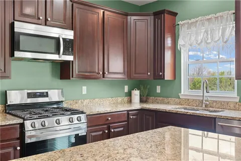 a kitchen with granite countertop a sink and a wooden floor
