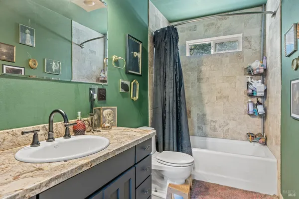 a bathroom with a granite countertop sink toilet and shower