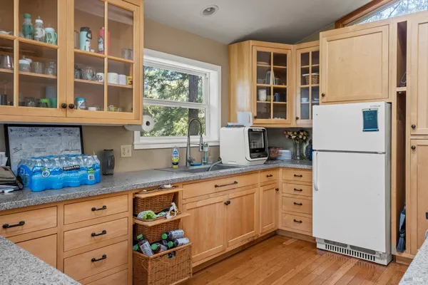 a kitchen with stainless steel appliances white cabinets and wooden floors