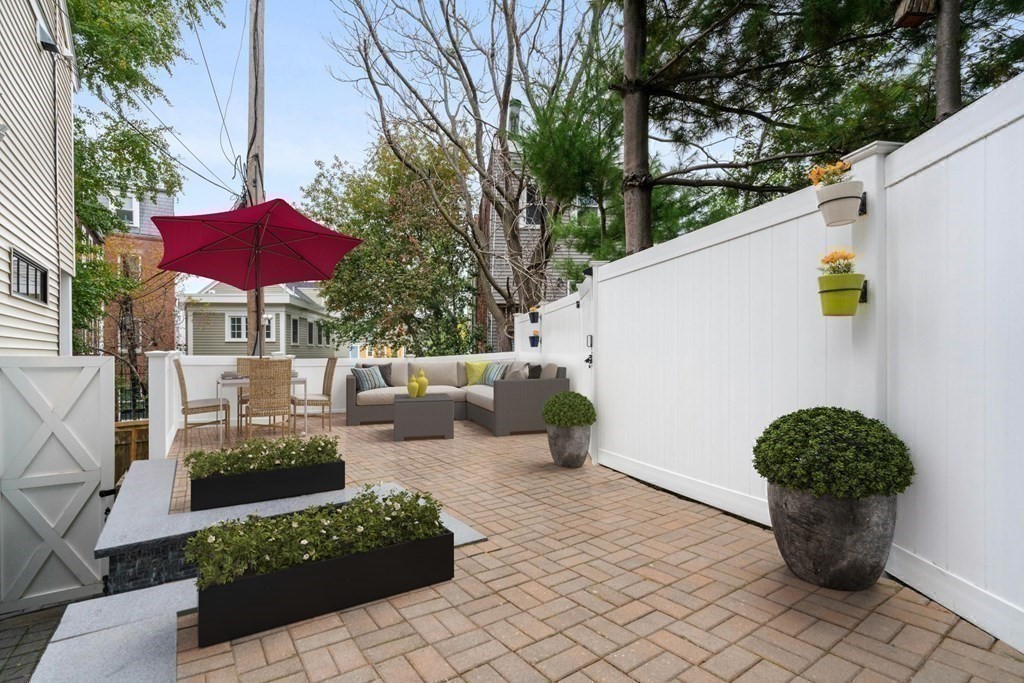 a view of a patio with chairs and potted plants