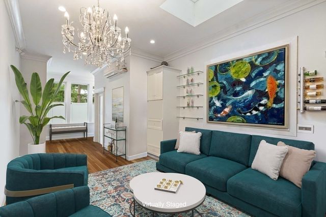 a living room with furniture a chandelier and a rug