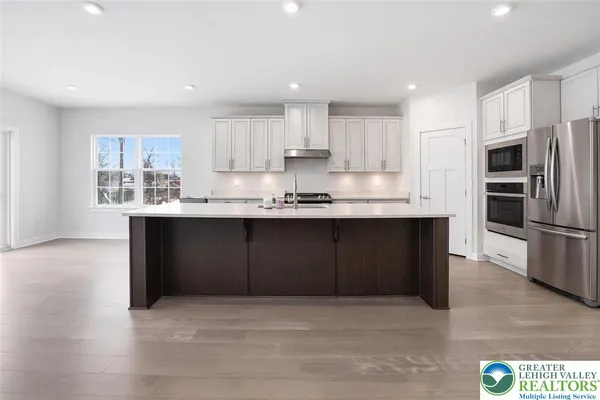 a kitchen with stainless steel appliances and wooden floor