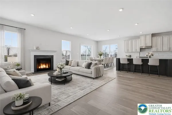 a view of an empty room with wooden floor and a fireplace