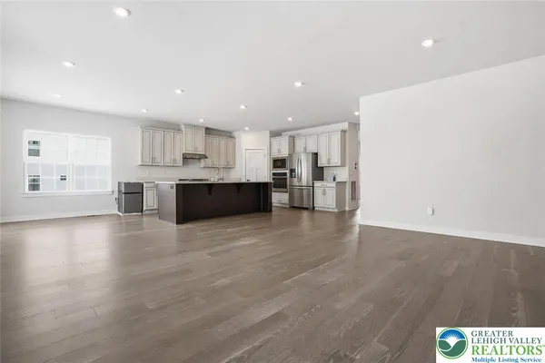a large kitchen with a large counter top stainless steel appliances and cabinets