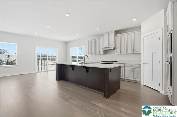 a kitchen with stainless steel appliances sink stove and cabinets
