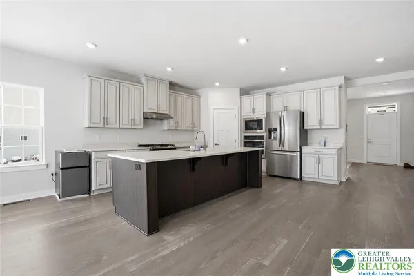 a kitchen with stainless steel appliances granite countertop a sink and white cabinets