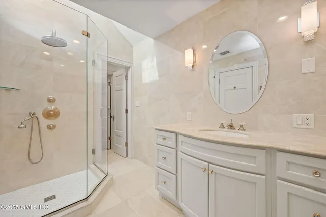 a bathroom with a double vanity sink mirror and shower