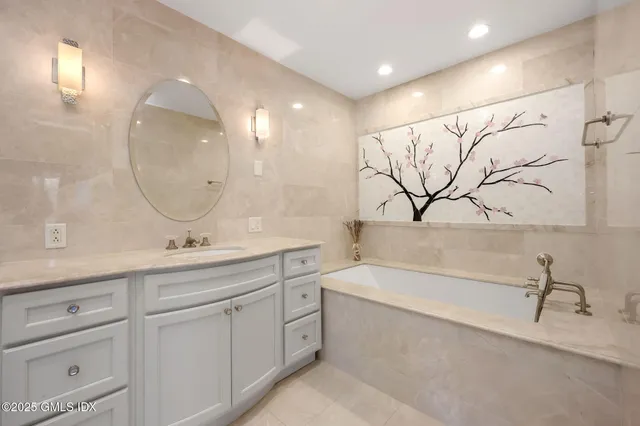 a bathroom with a double vanity sink mirror and bathtub