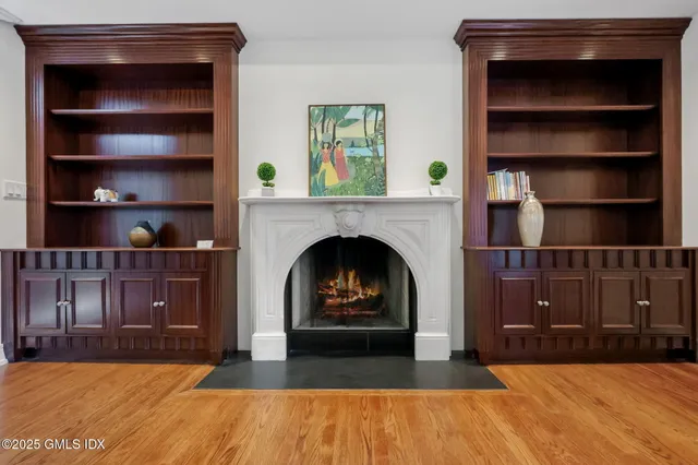 a living room with a fireplace cabinet and a fireplace