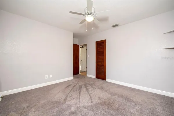 an empty room with fan and a ceiling fan